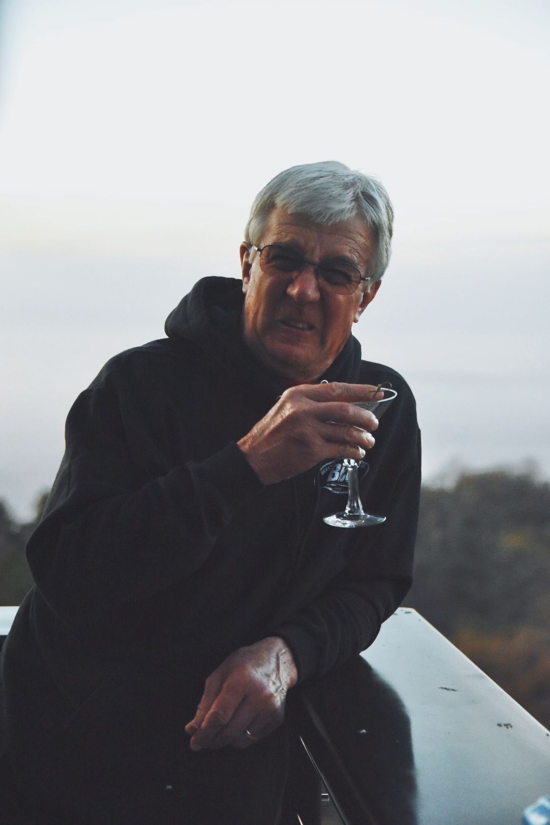 A man raising a glass by the water