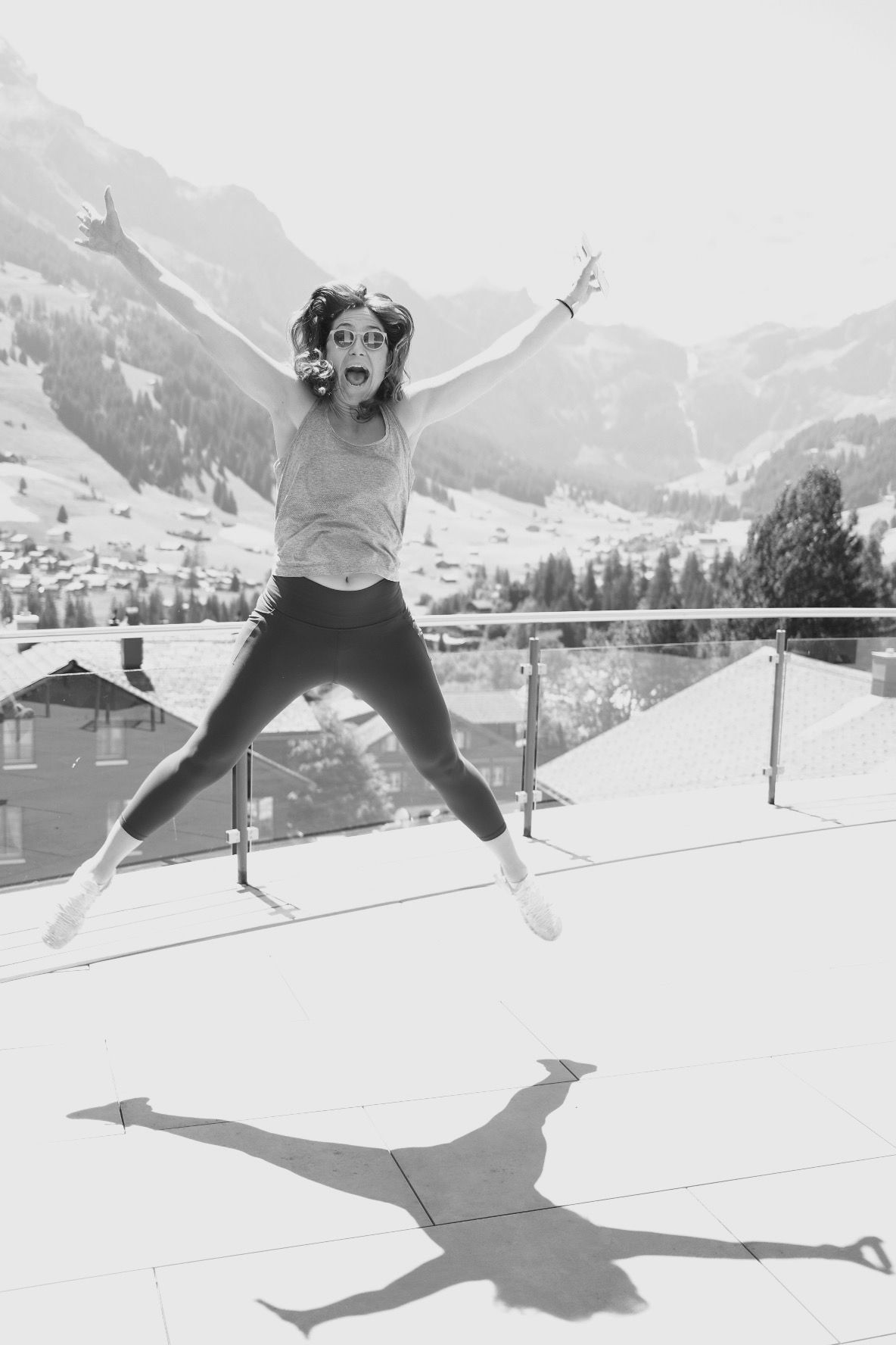 Woman mid-jump on a snowy terrace, in black and white
