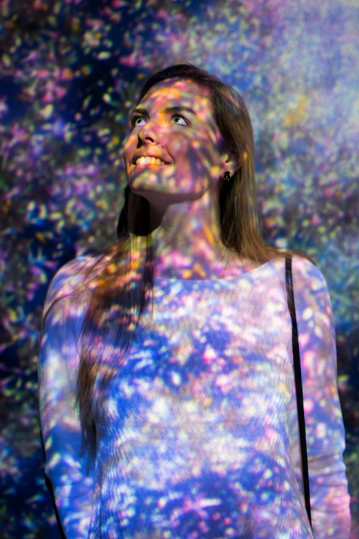 Woman lit by projected flowers
