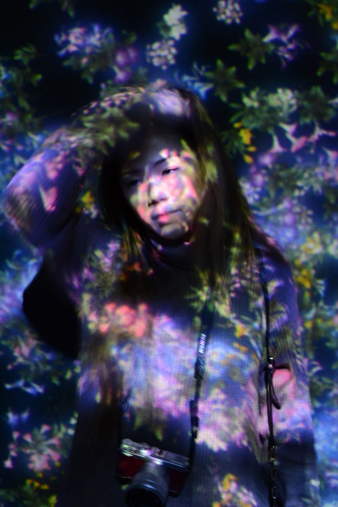 Woman in a room of projected flowers