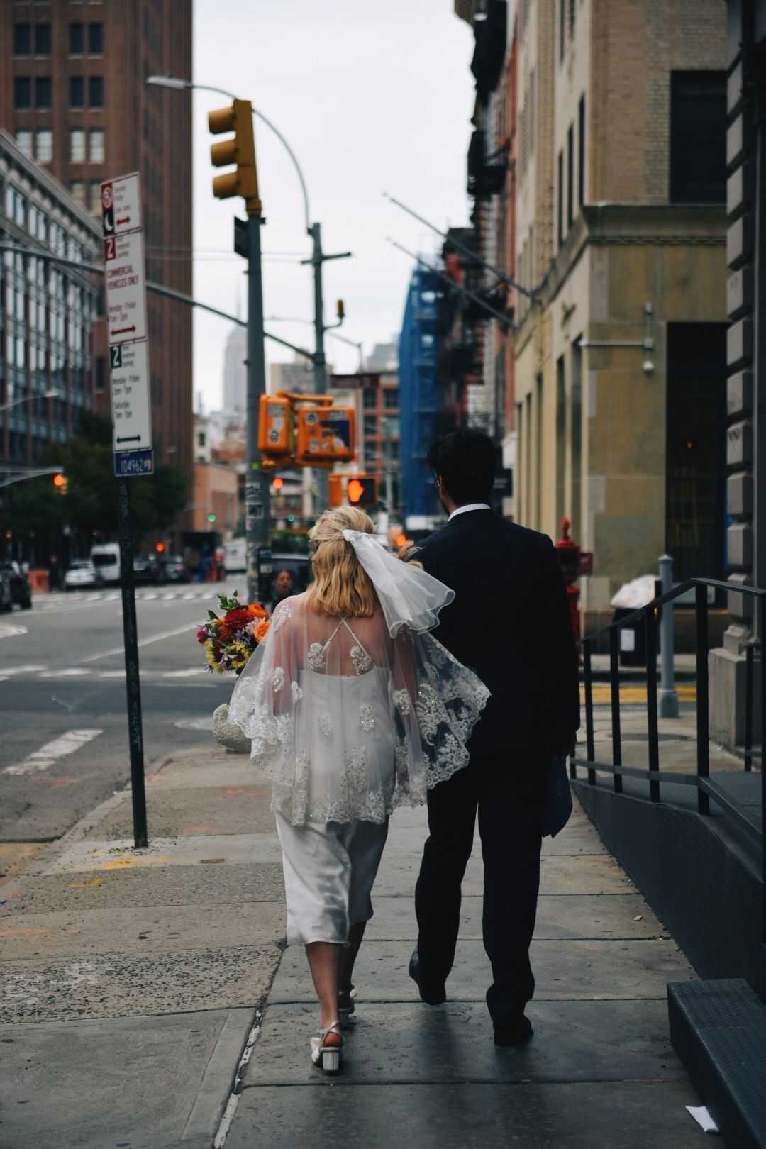 The couple walking down a city street, seen from behind
